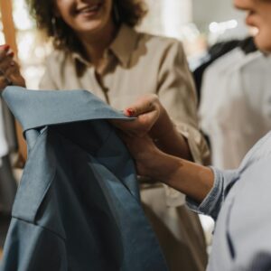 Women examining a blue garment in a modern boutique, highlighting a shopping experience.
